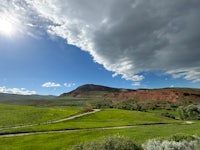 a view of a grassy field with a cloudy sky