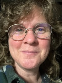 a woman wearing glasses and a plaid shirt